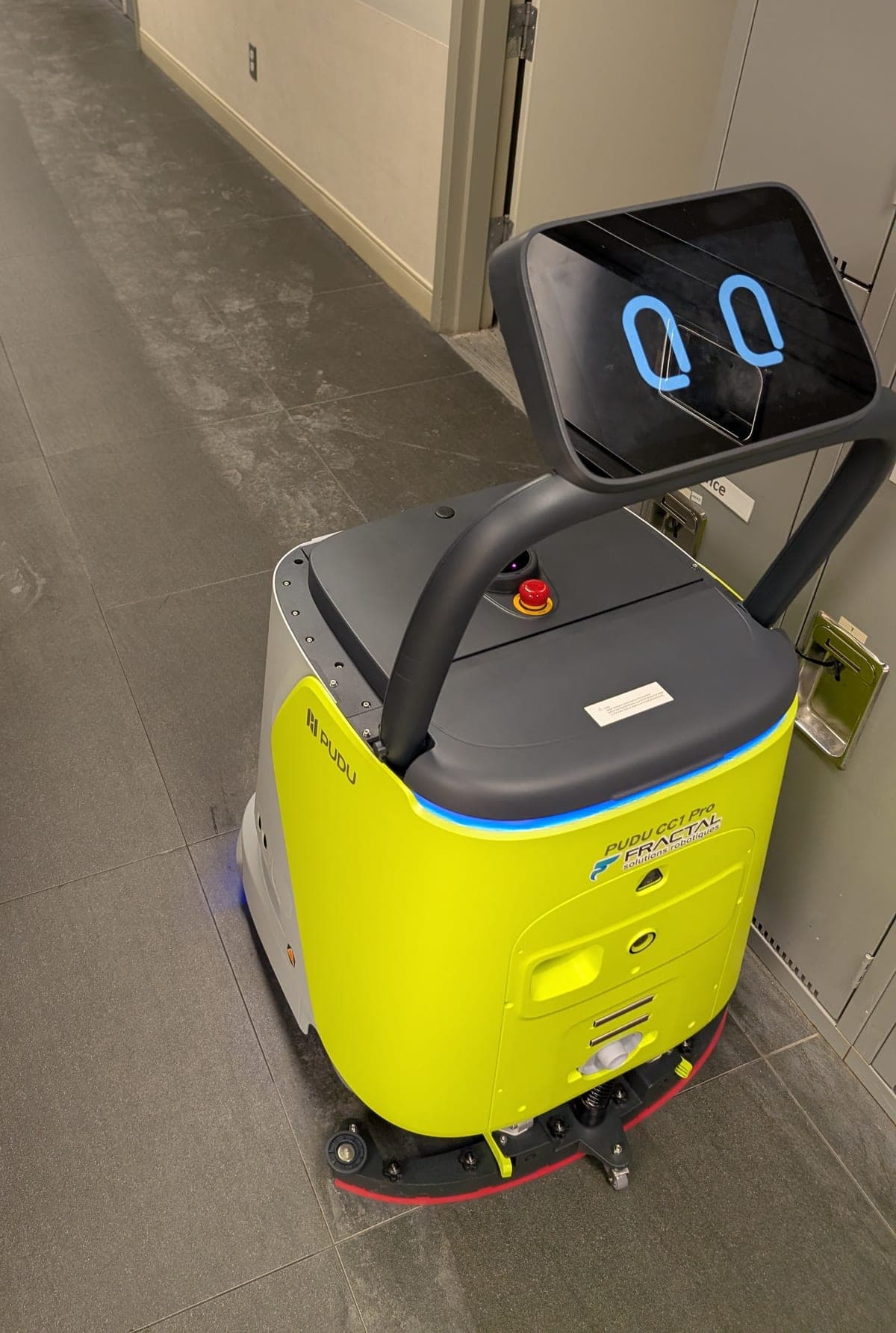 Pudu CC1 Pro cleaning robot in Fractal colours in a corridor covered with white salt footprints
